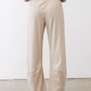 Light beige loose work pants with elastic waistband and cuffed ankle hem