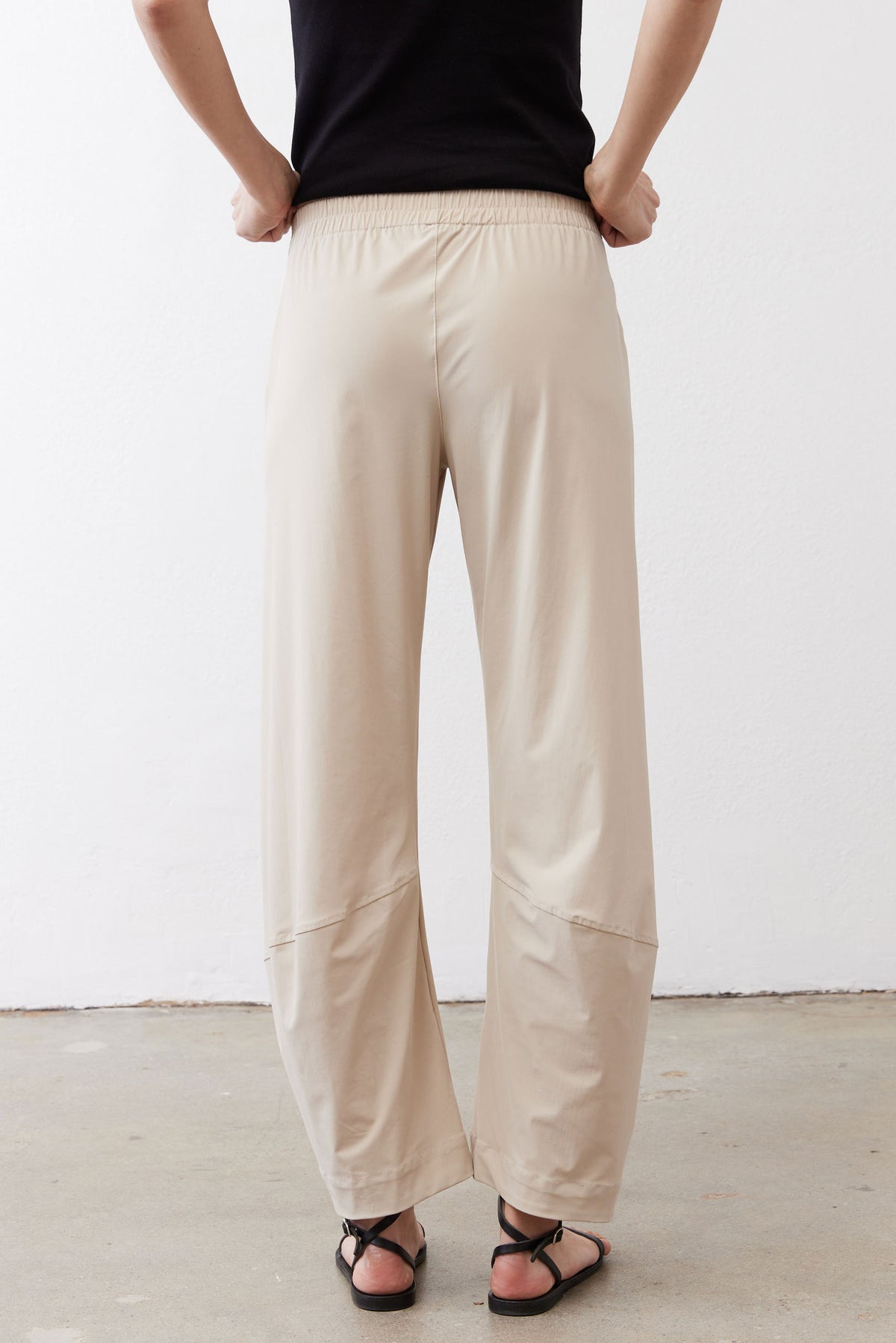 Light beige loose work pants with elastic waistband and cuffed ankle hem