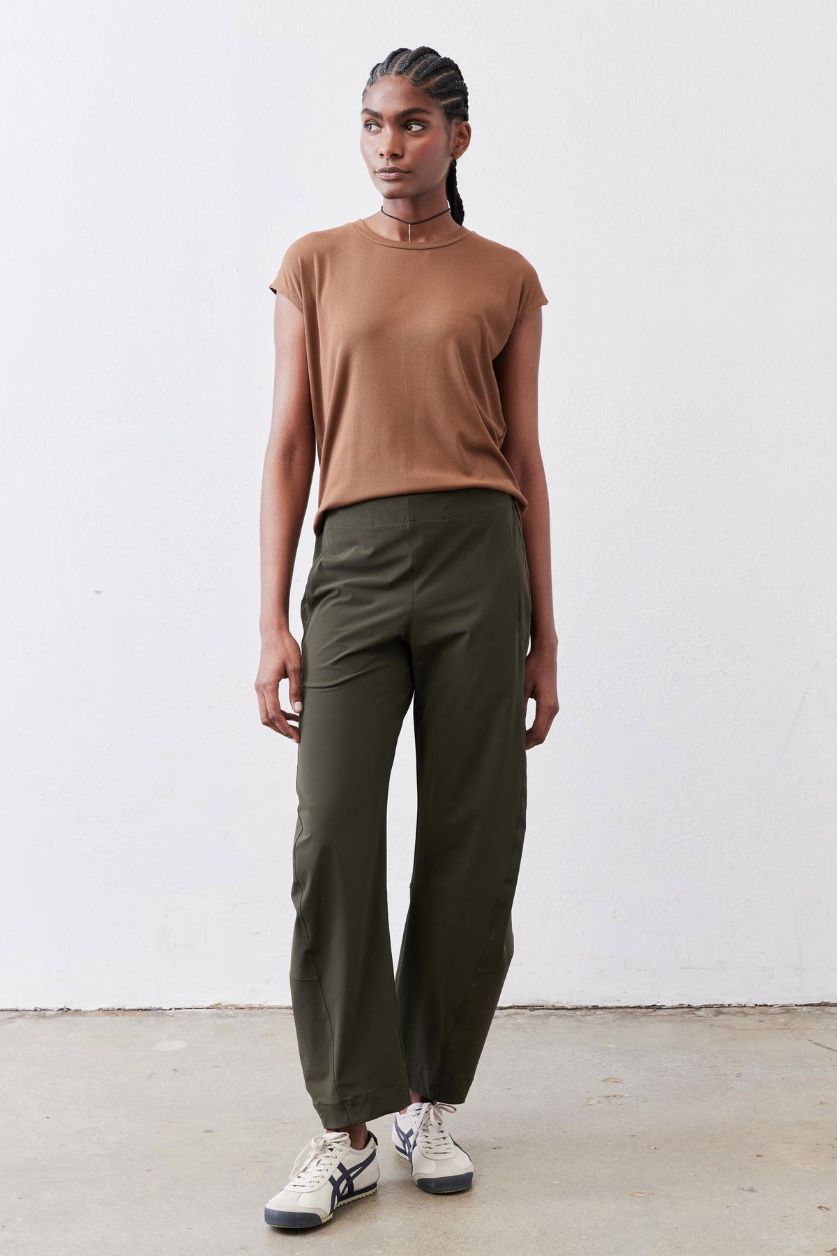 Olive green loose work pants with elastic waist and relaxed ankle-length silhouette