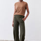 Olive green loose work pants with elastic waist and side pocket, angled view