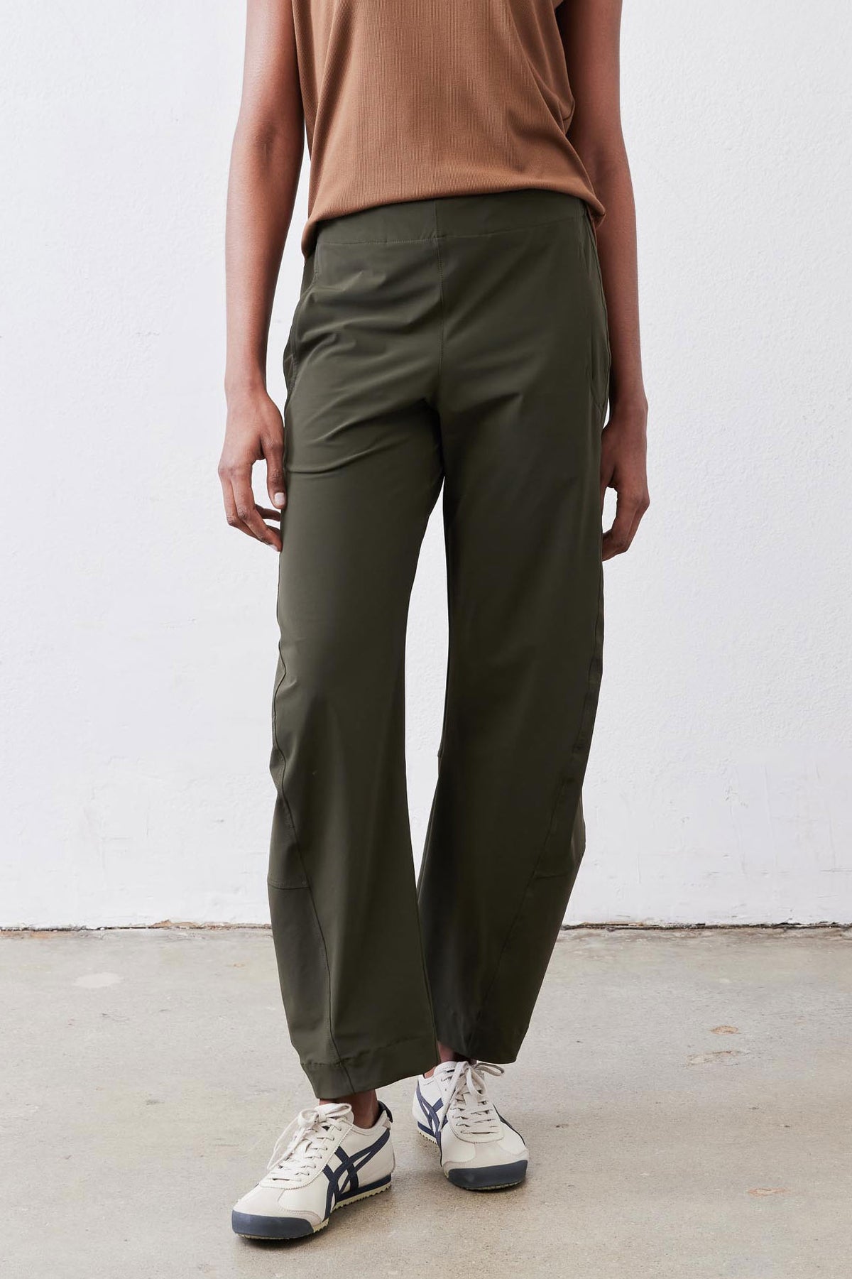 Olive green loose work pants with tapered ankle, side pockets, and elastic waist