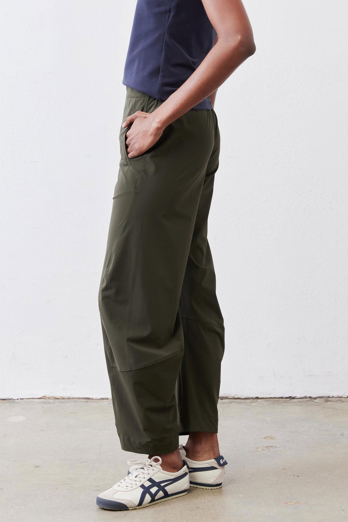 Olive green loose work pants with patch pocket and tapered ankle-length leg