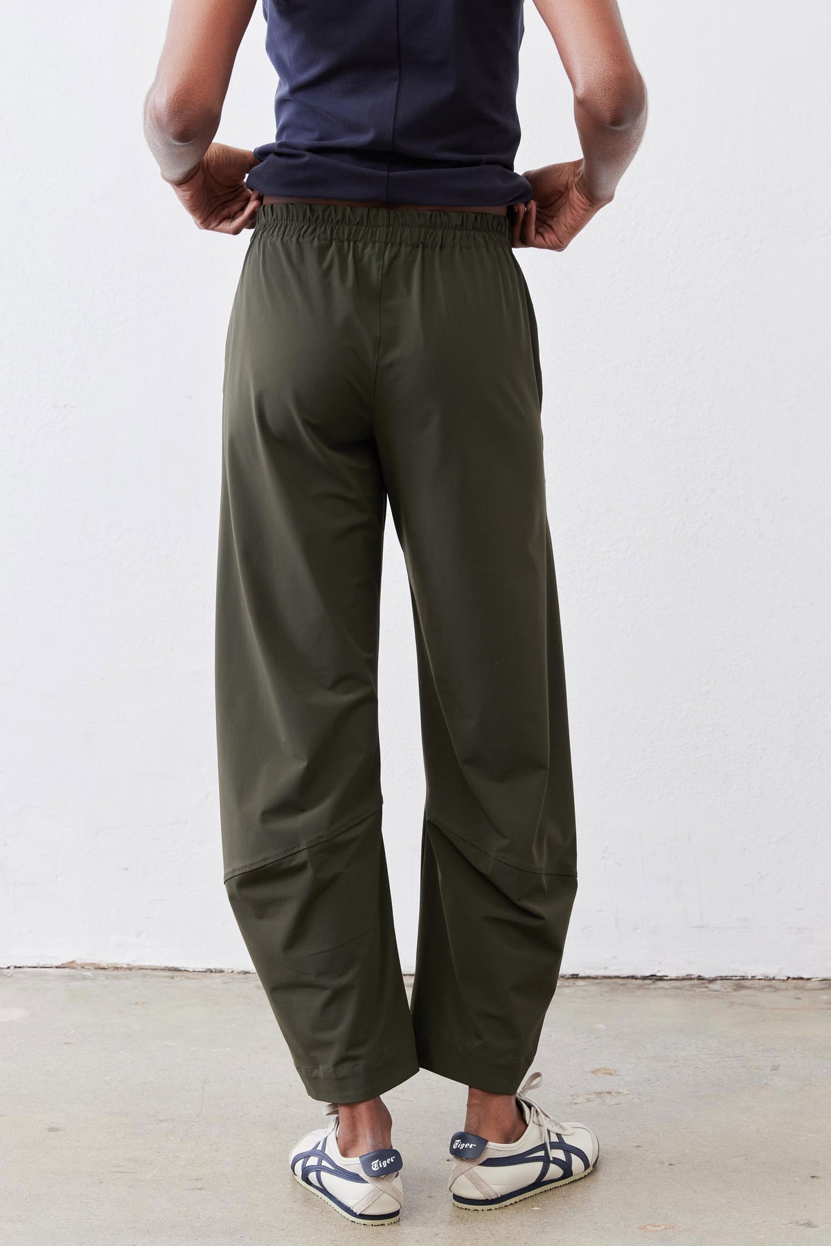 Olive green loose work pants with elastic waistband and roomy ankle-length fit