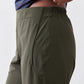 Olive green loose work pants with elastic waistband and side pocket, close-up