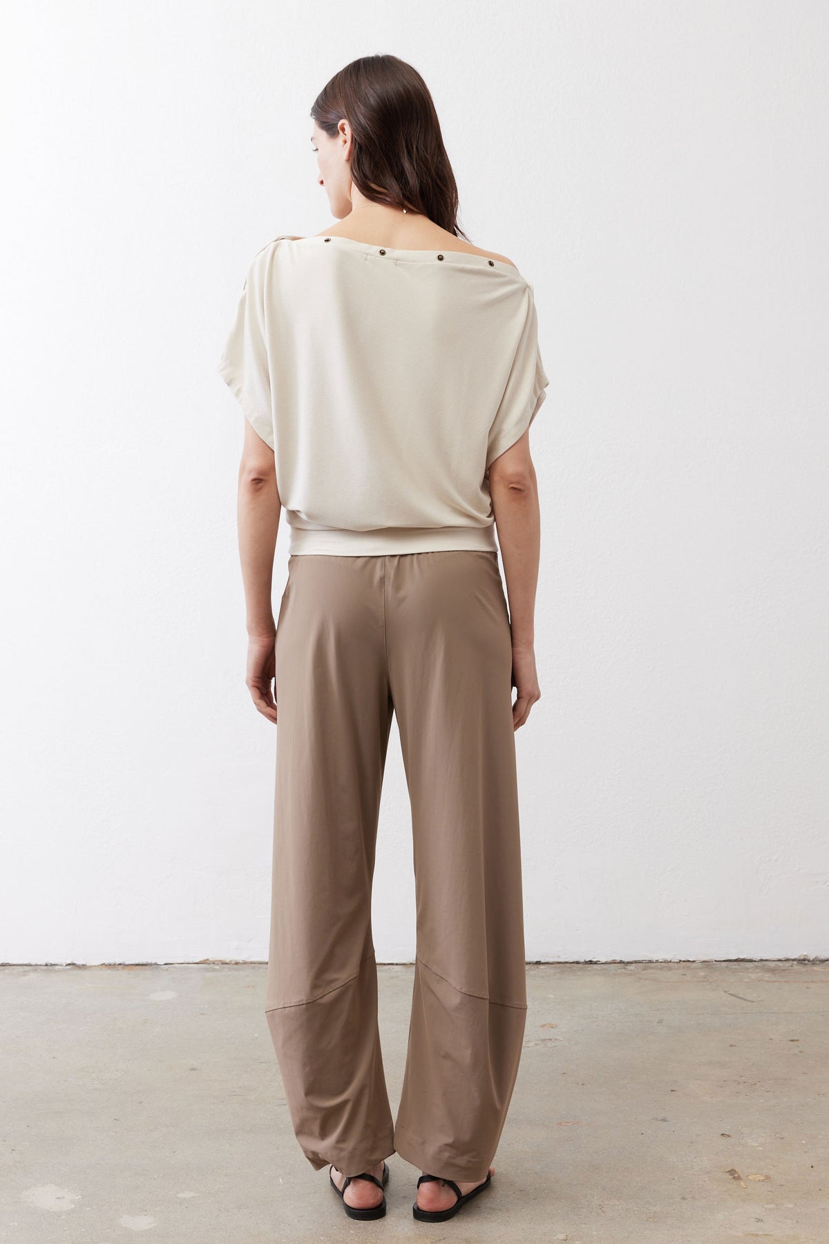 Tan work pants from back view with elastic waist and tapered ankle cuffs