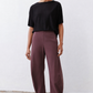 Loose aubergine work pants with wide legs and tapered ankle length, front pockets