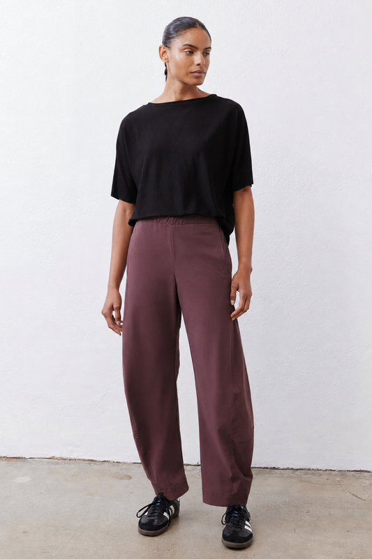 Loose aubergine work pants with wide legs and tapered ankle length, front pockets
