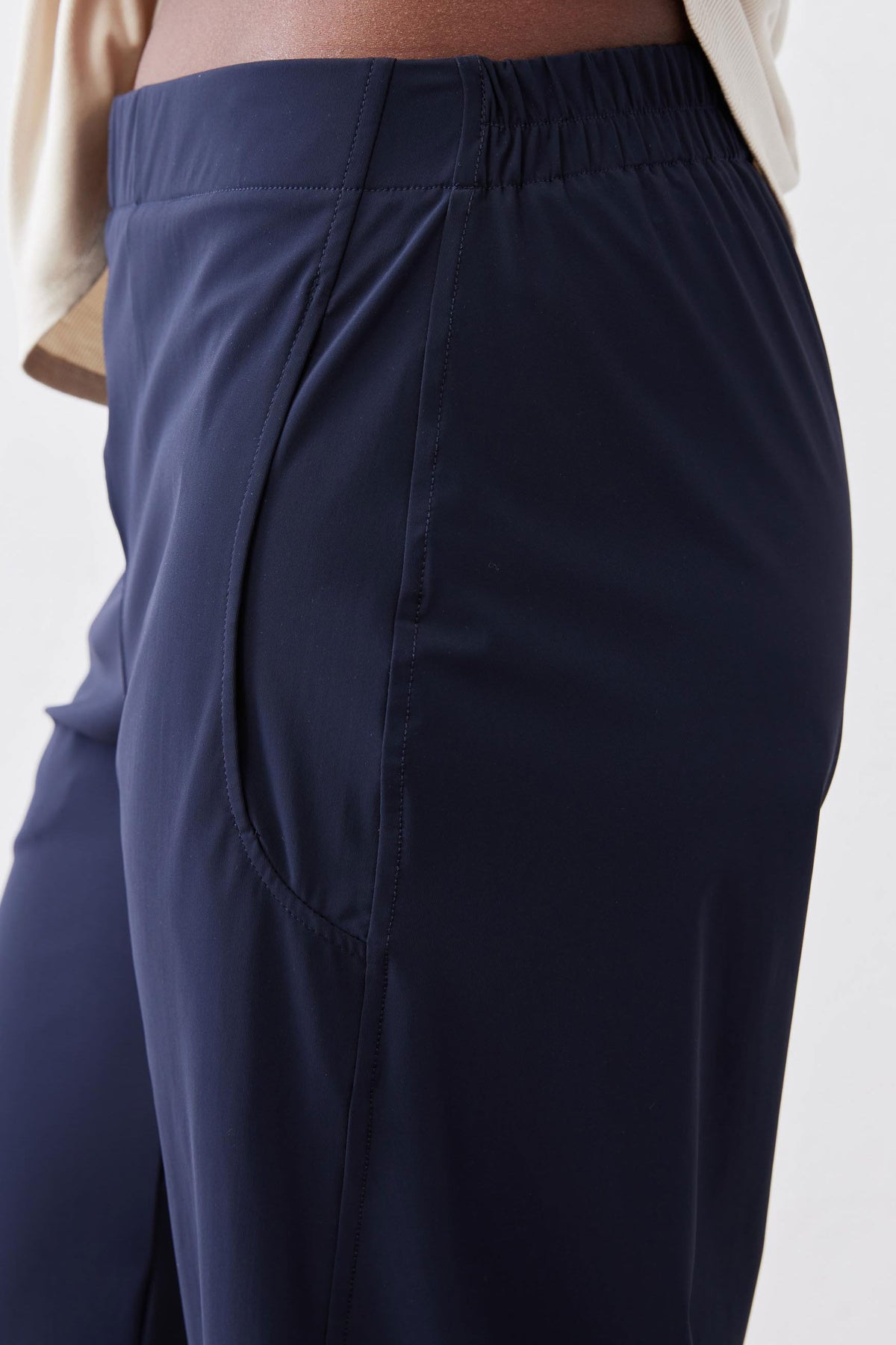 Navy waistband and front seam detail on loose work pants with gathered elastic back