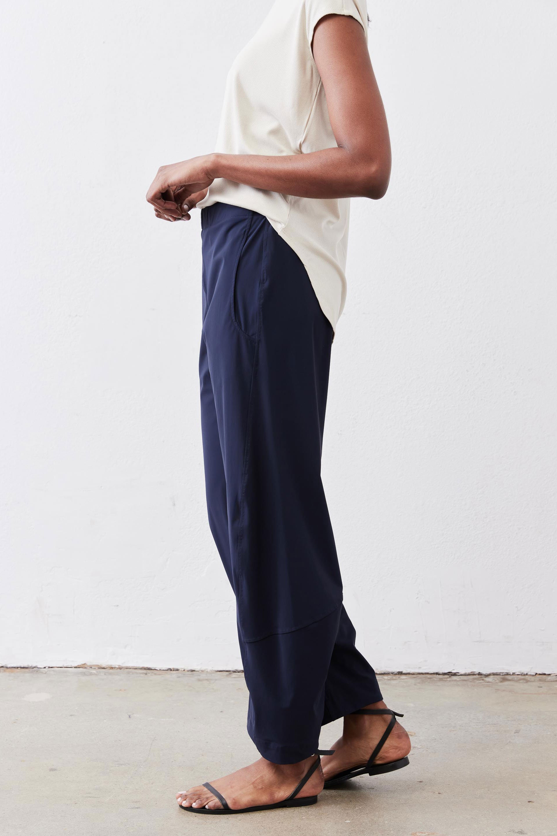 Navy work pants shown in side view with elastic waist and cuffed hem