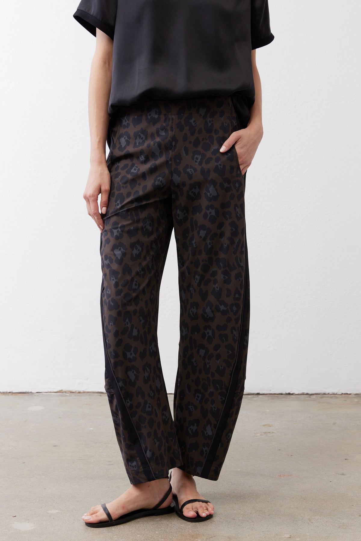 Loose work pants in dark leopard print with elastic waistband and ankle-length relaxed fit
