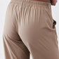 Tan pants close-up: elastic waistband with relaxed drape and smooth fabric texture