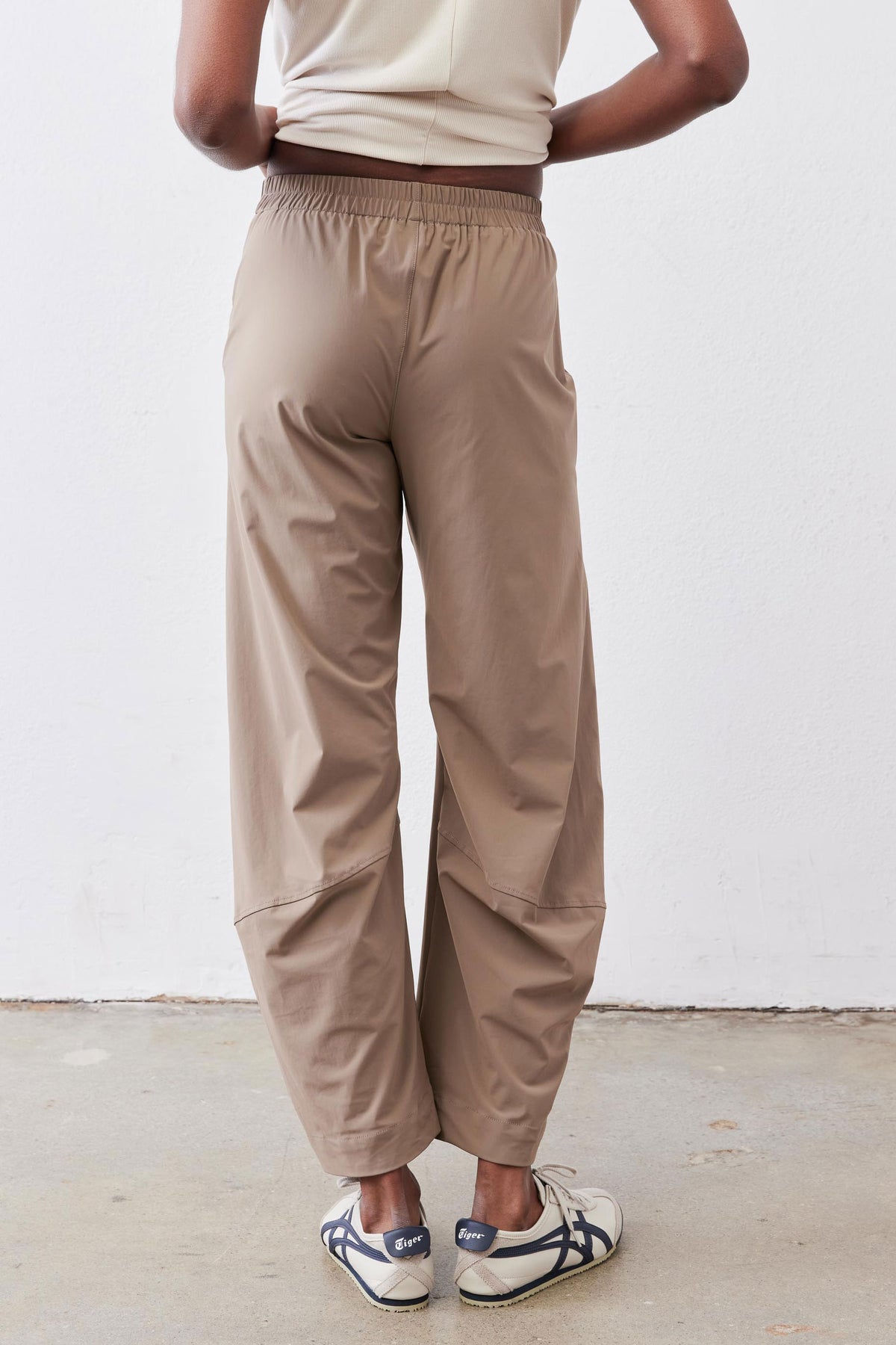 Tan loose work pants front view; elastic waistband and wide-to-tapered legs