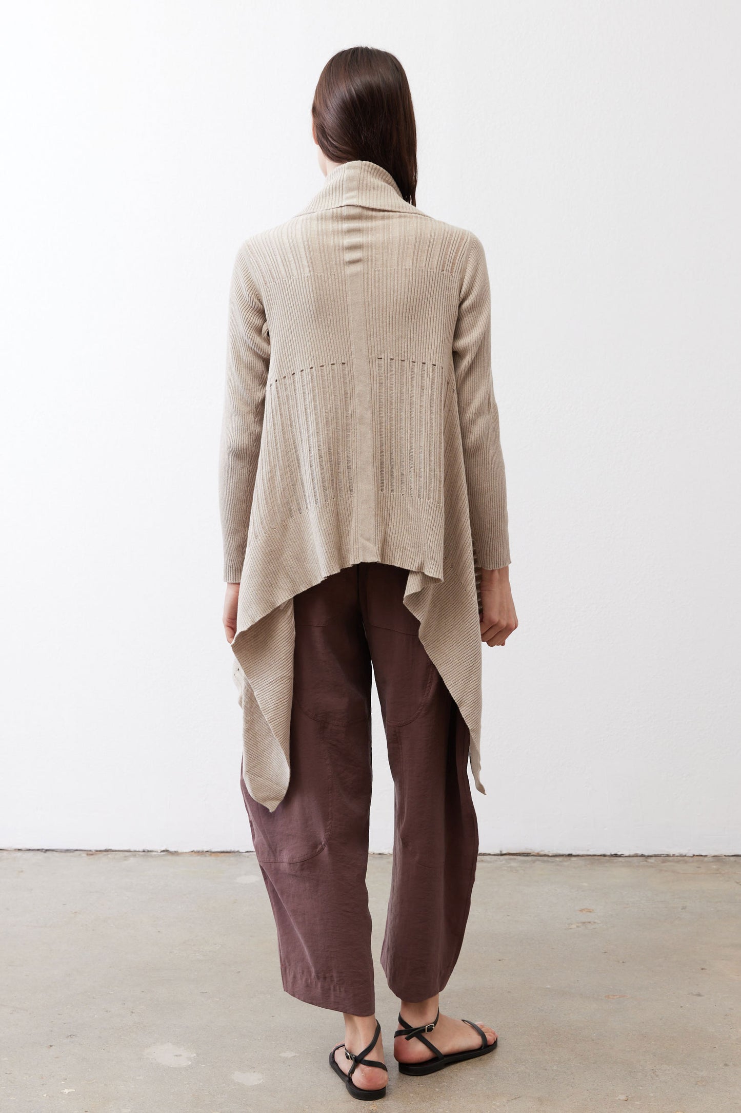Light beige open knit cardigan shown from the back, long sleeves, draped hem