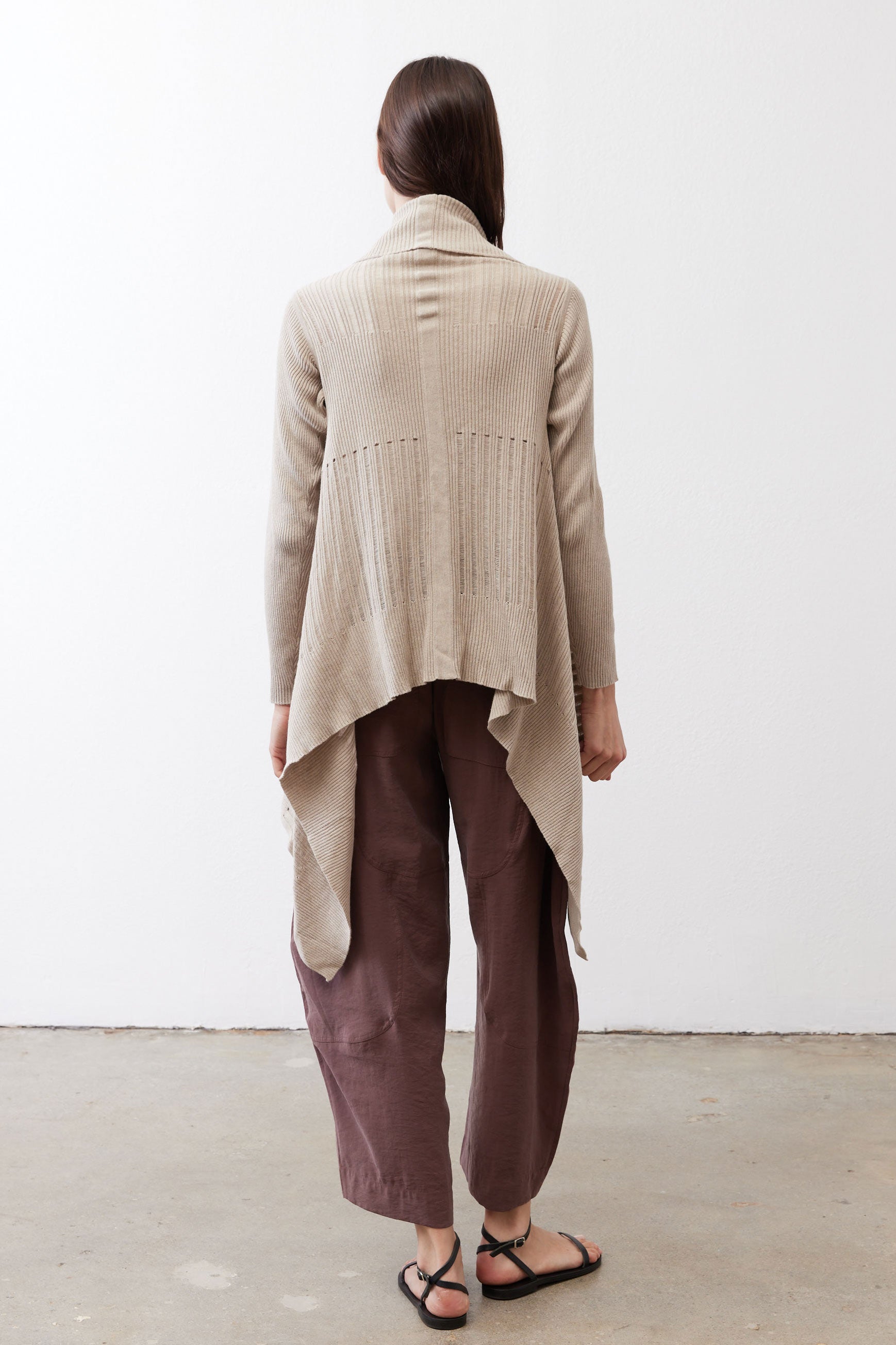 Light beige open knit cardigan shown from the back, long sleeves, draped hem
