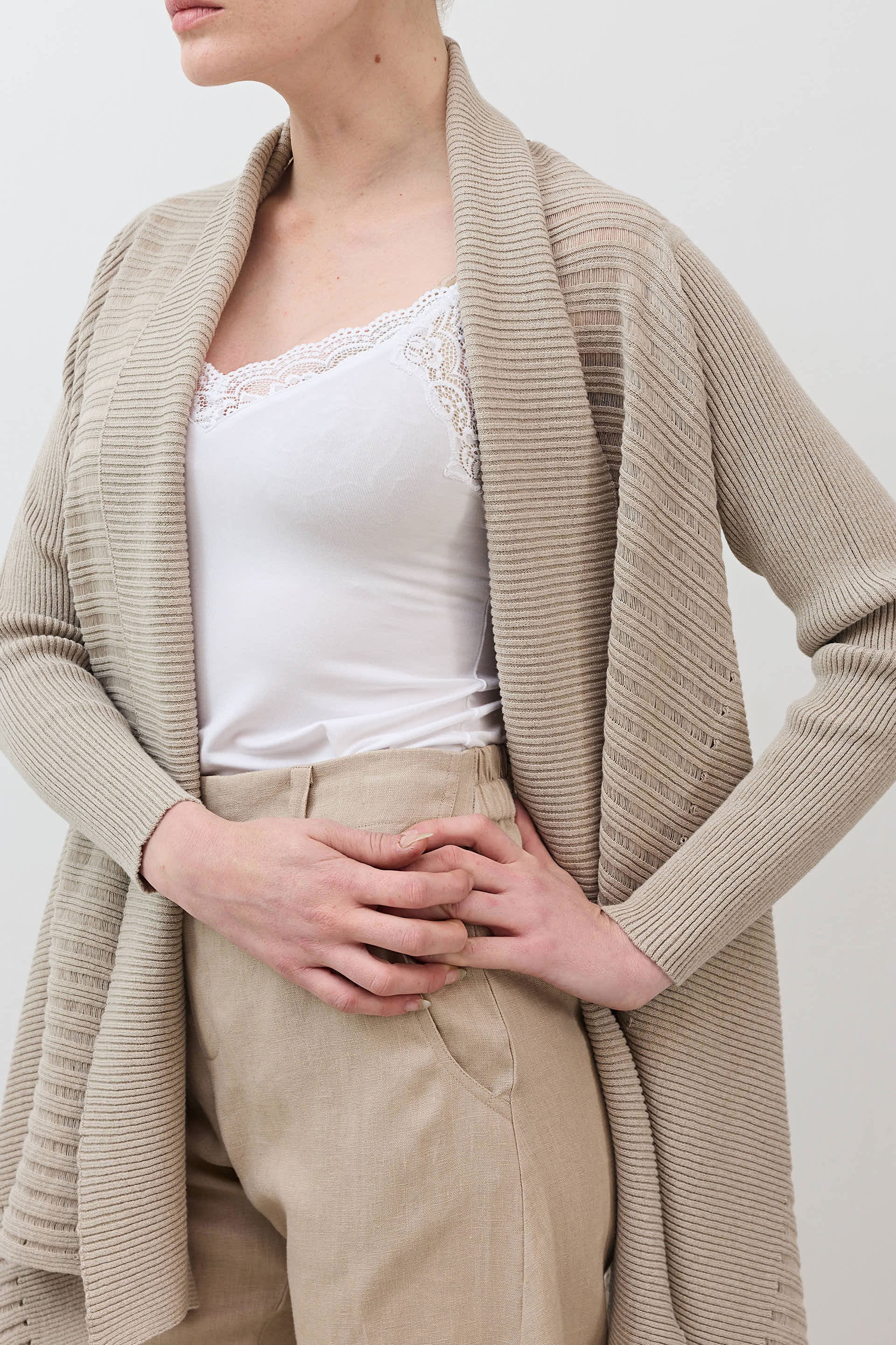 Open knit cardigan in light beige, close-up of draped neckline and long sleeves