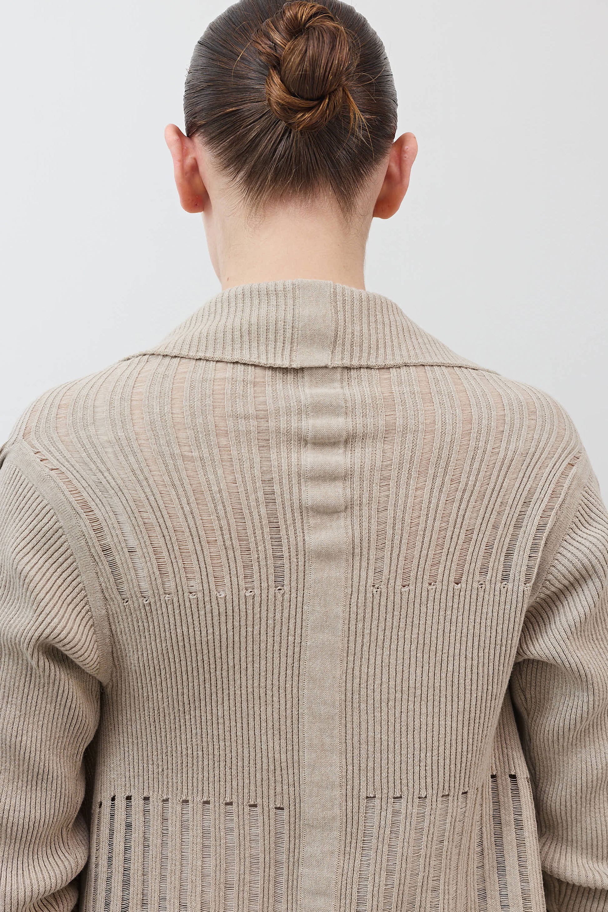 Open knit cardigan back view in light beige, ribbed texture and vertical seam detail
