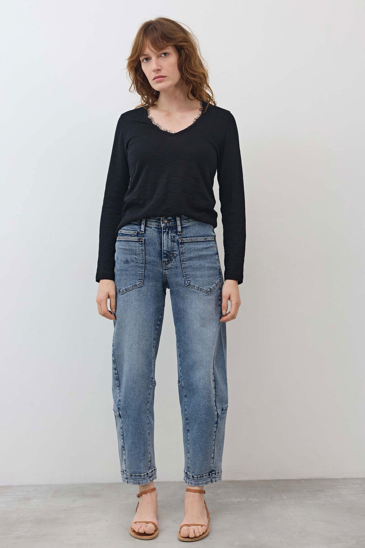 Black lace-trim V-neck long-sleeve top paired with jeans and tan sandals