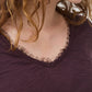 Close-up of lace-trim V-neck on dark plum long sleeve top