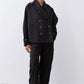 Black oversized nylon trench with double-breasted button front and wide collar.