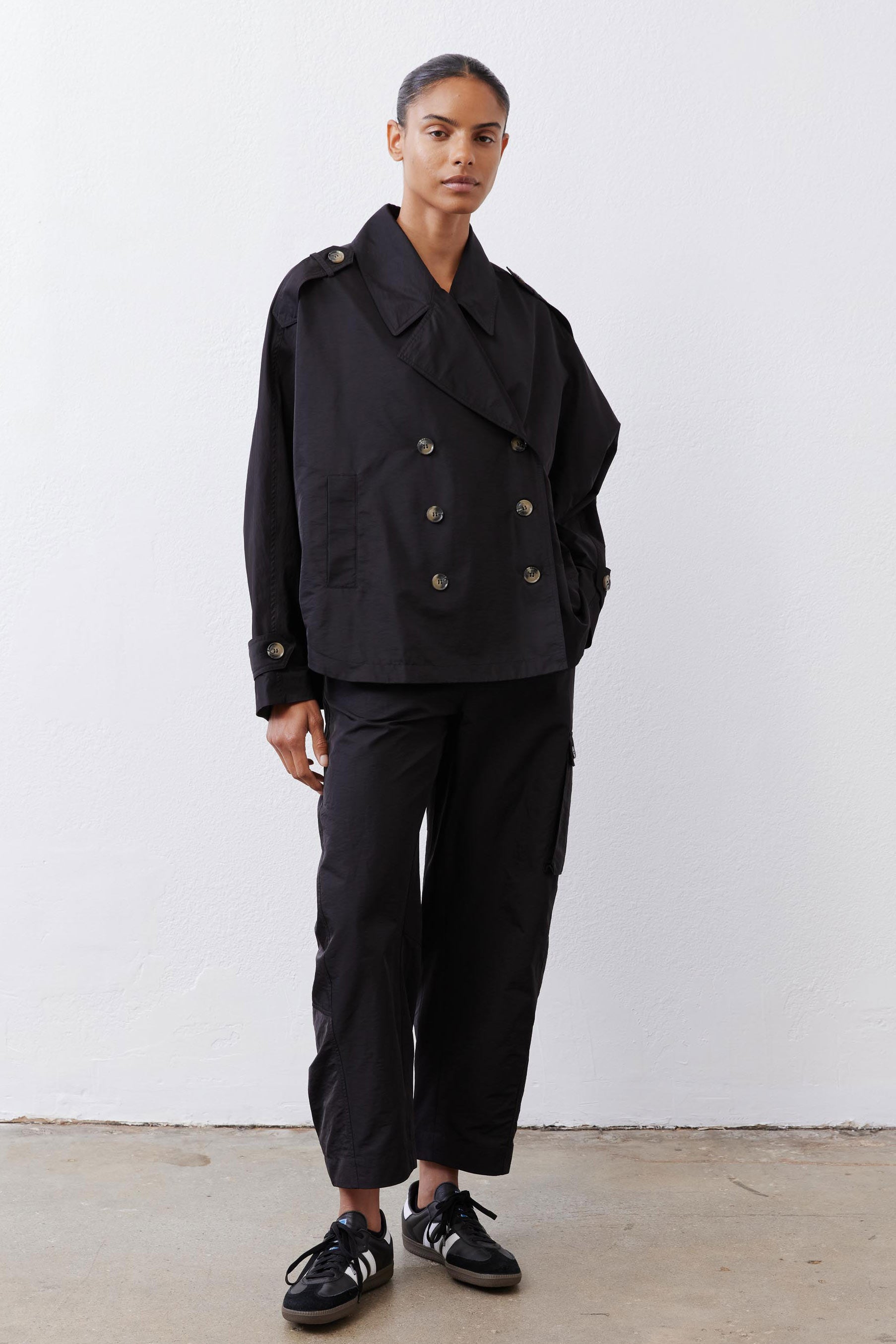Black oversized nylon trench with double-breasted button front and wide collar.