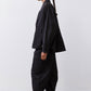 Black oversized nylon trench in side profile with relaxed fit and long hem.