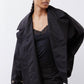 Black oversized nylon trench with open front, snap details, and flap pocket at chest.