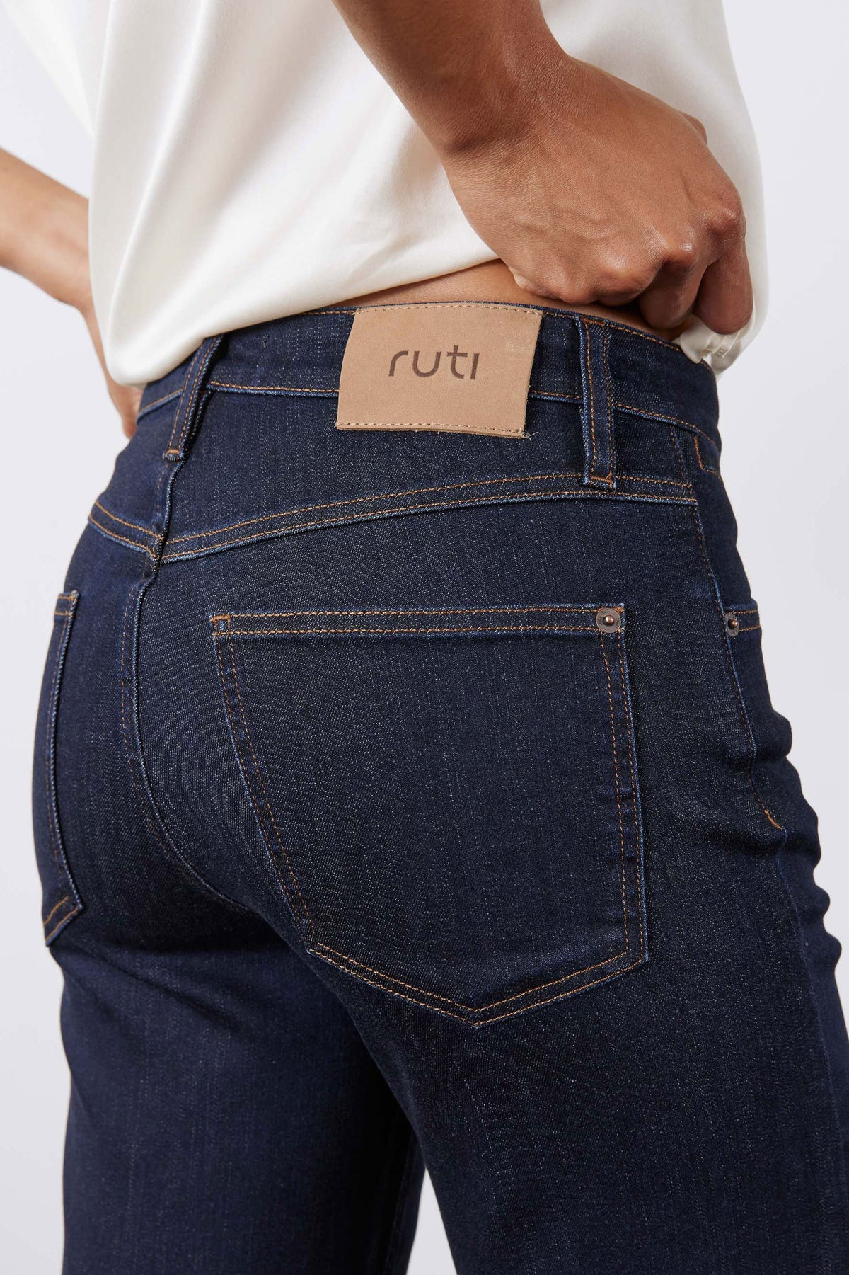 Dark blue palazzo jeans close-up: high waist, front button, side pockets, logo patch