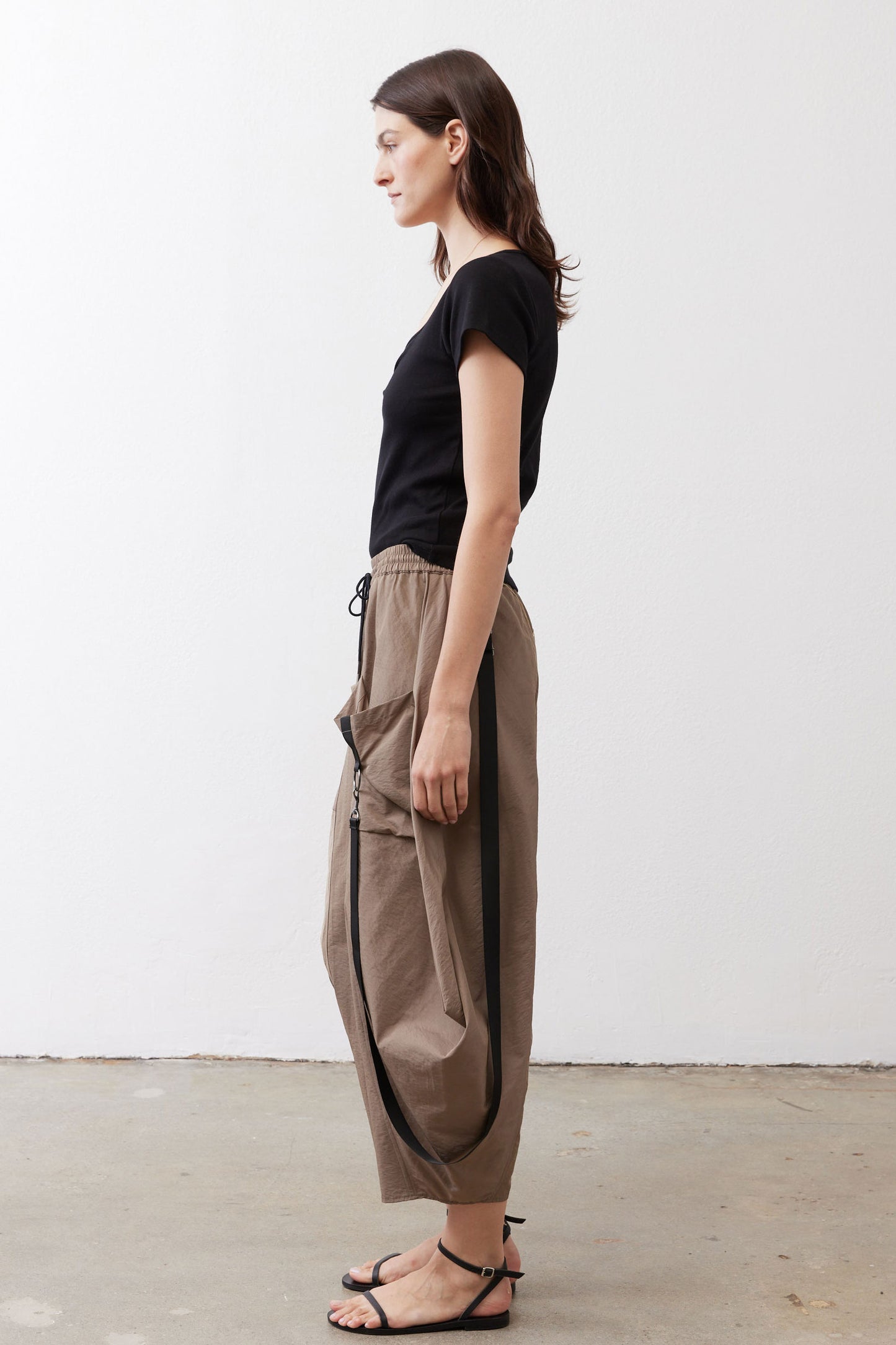Walnut brown wide-leg pants shown from the side, elastic waist and cargo pocket detail