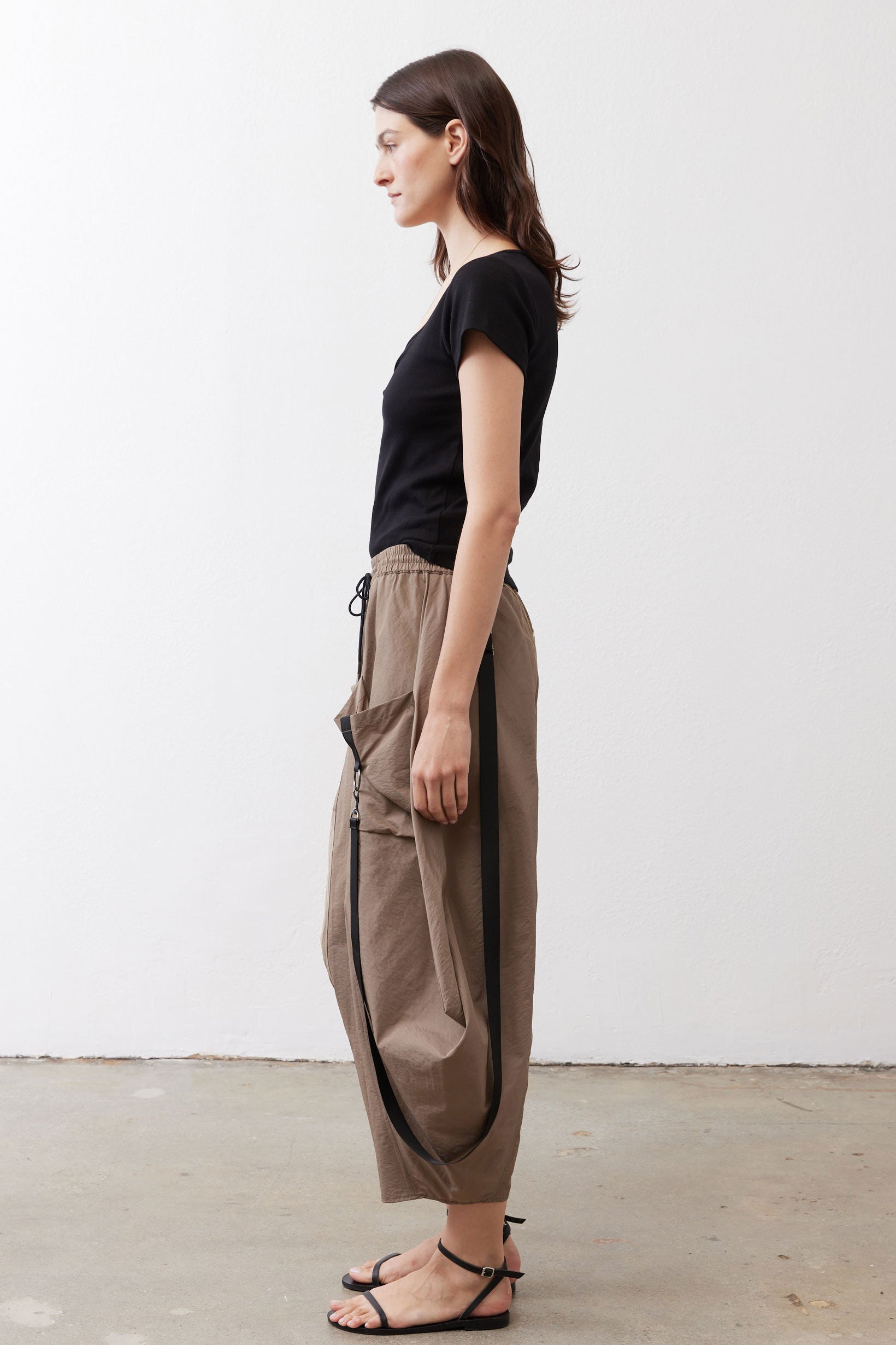 Walnut brown wide-leg pants shown from the side, elastic waist and cargo pocket detail