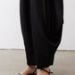 Black wide-leg parachute pants with ankle-cropped cuffs and side pocket hardware.