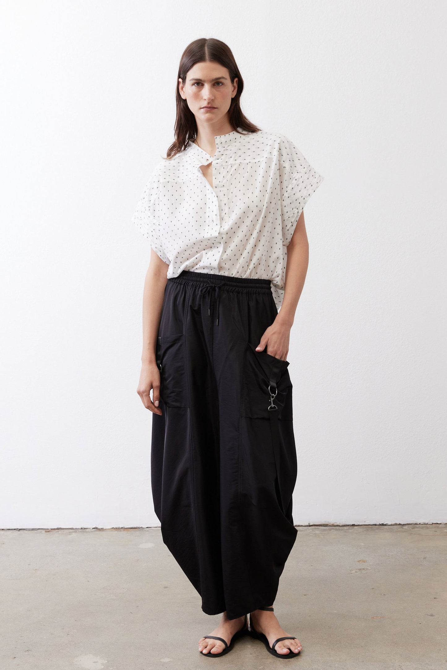 Black parachute wide-leg pants with drawstring waist, roomy legs, and side loops.