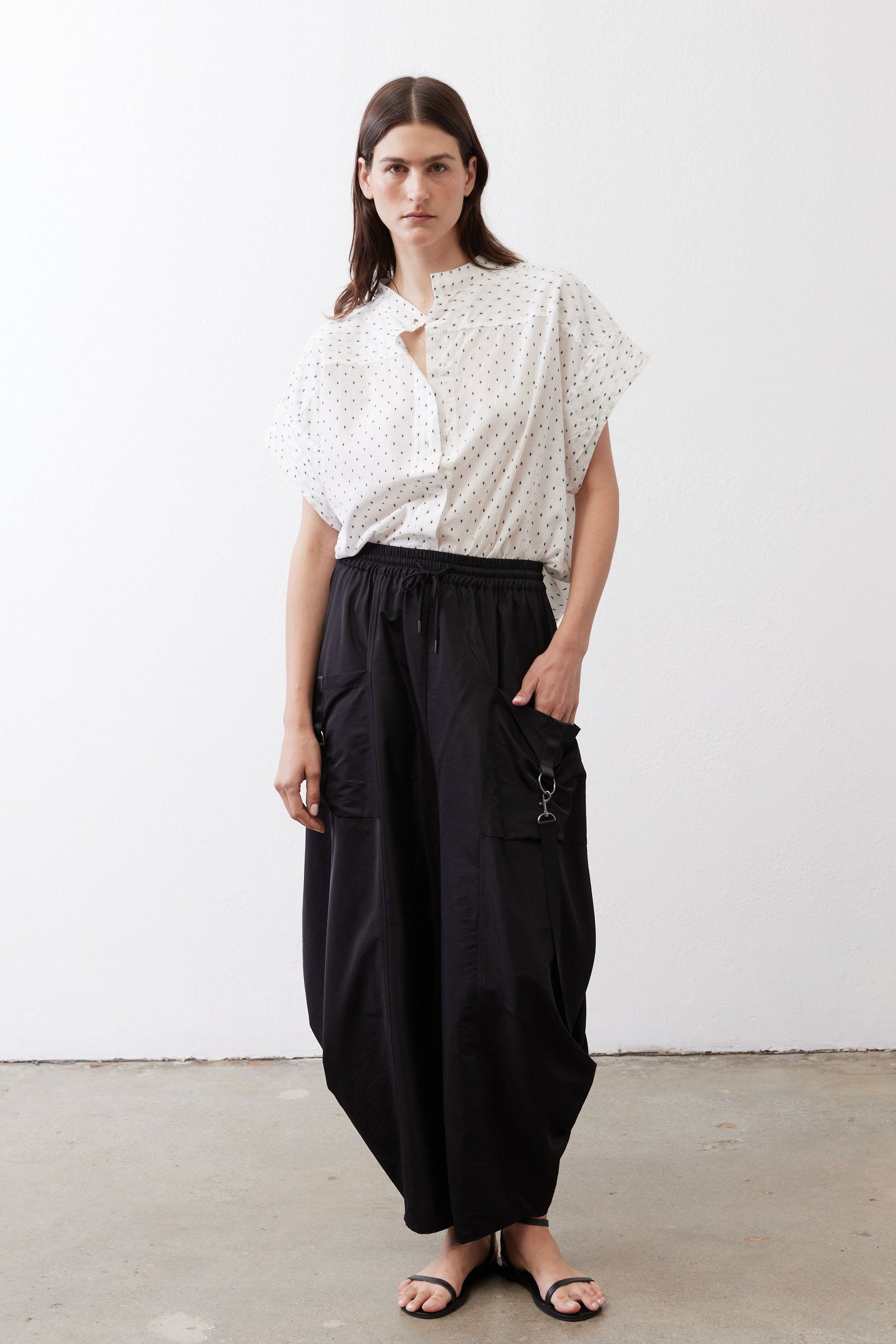 Black parachute wide-leg pants with drawstring waist, roomy legs, and side loops.