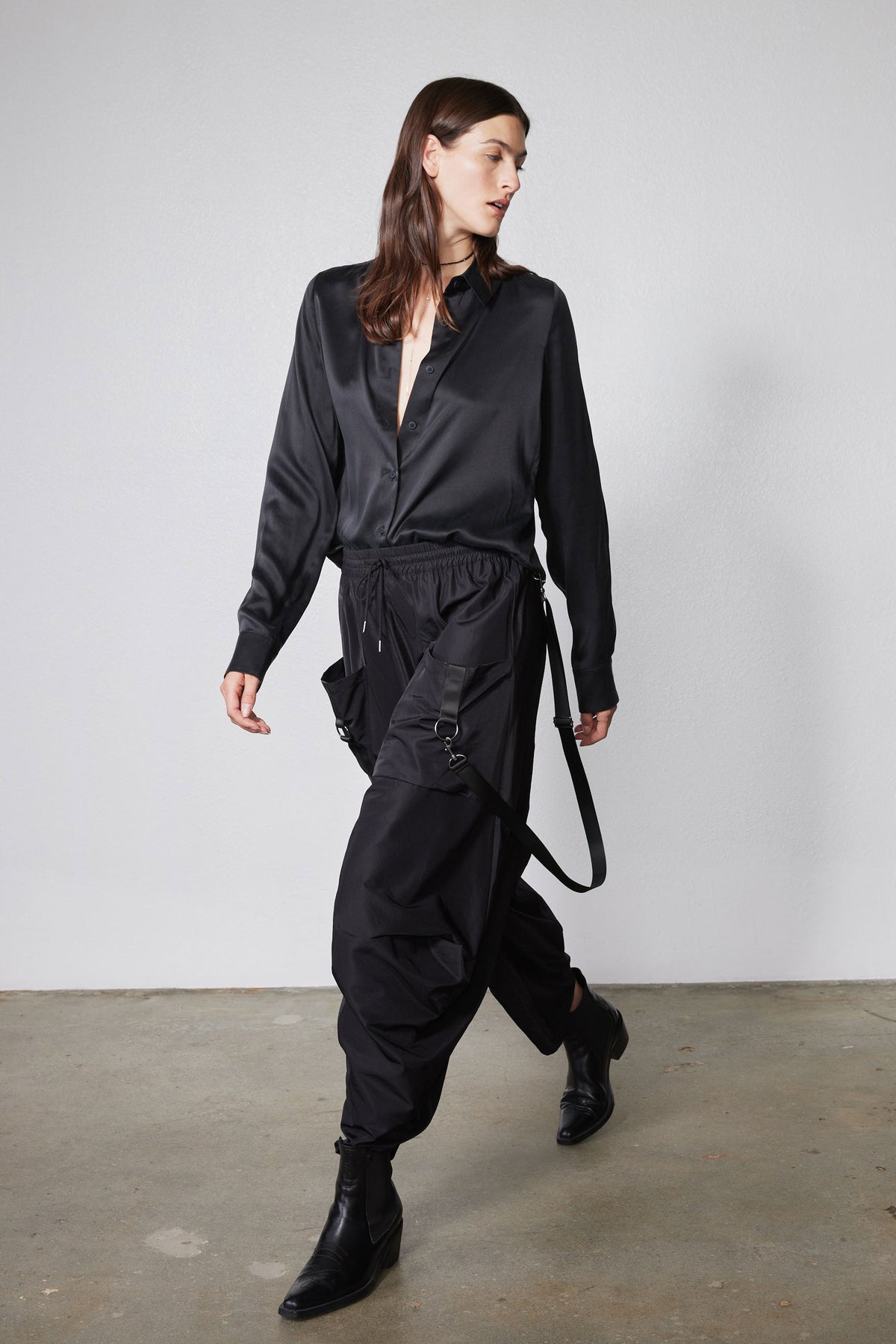 Black wide-leg parachute pants with drawstring waist and dangling side straps