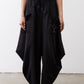 Black wide-leg parachute pants with elastic drawstring waist, draped legs, metal ring