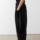 Black wide-leg parachute pants with side pocket detail and adjustable drawstring.