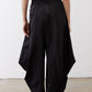 Black wide-leg parachute pants with elastic waist and large side cargo pockets.