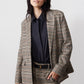 Brown plaid blazer with black elbow patches and dark buttoned shirt