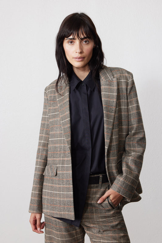 Brown plaid blazer with black elbow patches and notch lapel over dark shirt