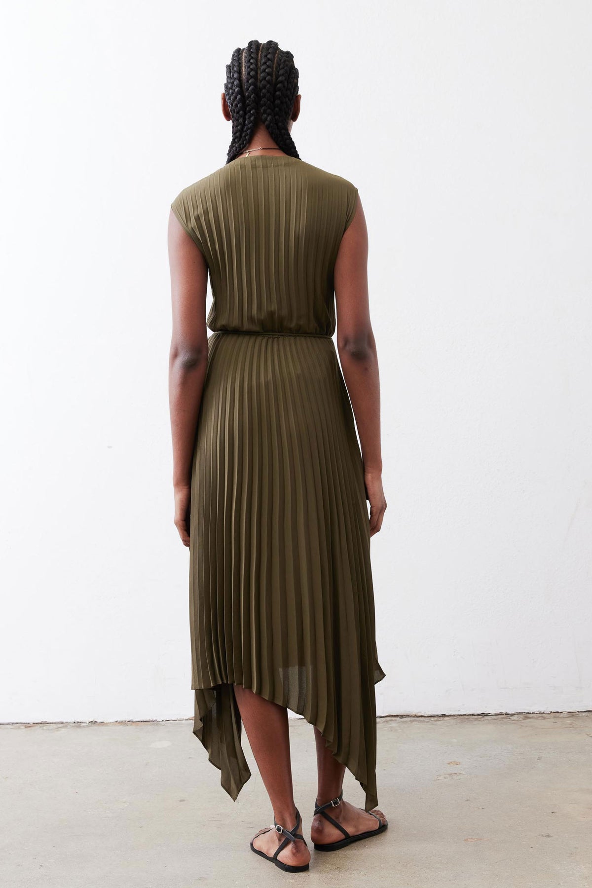 Olive pleated wrap dress, sleeveless back view with asymmetrical layered hem.