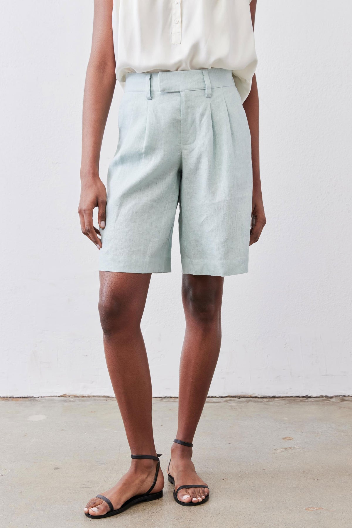 Mint pleated bermuda shorts, front view with belt loops and button closure