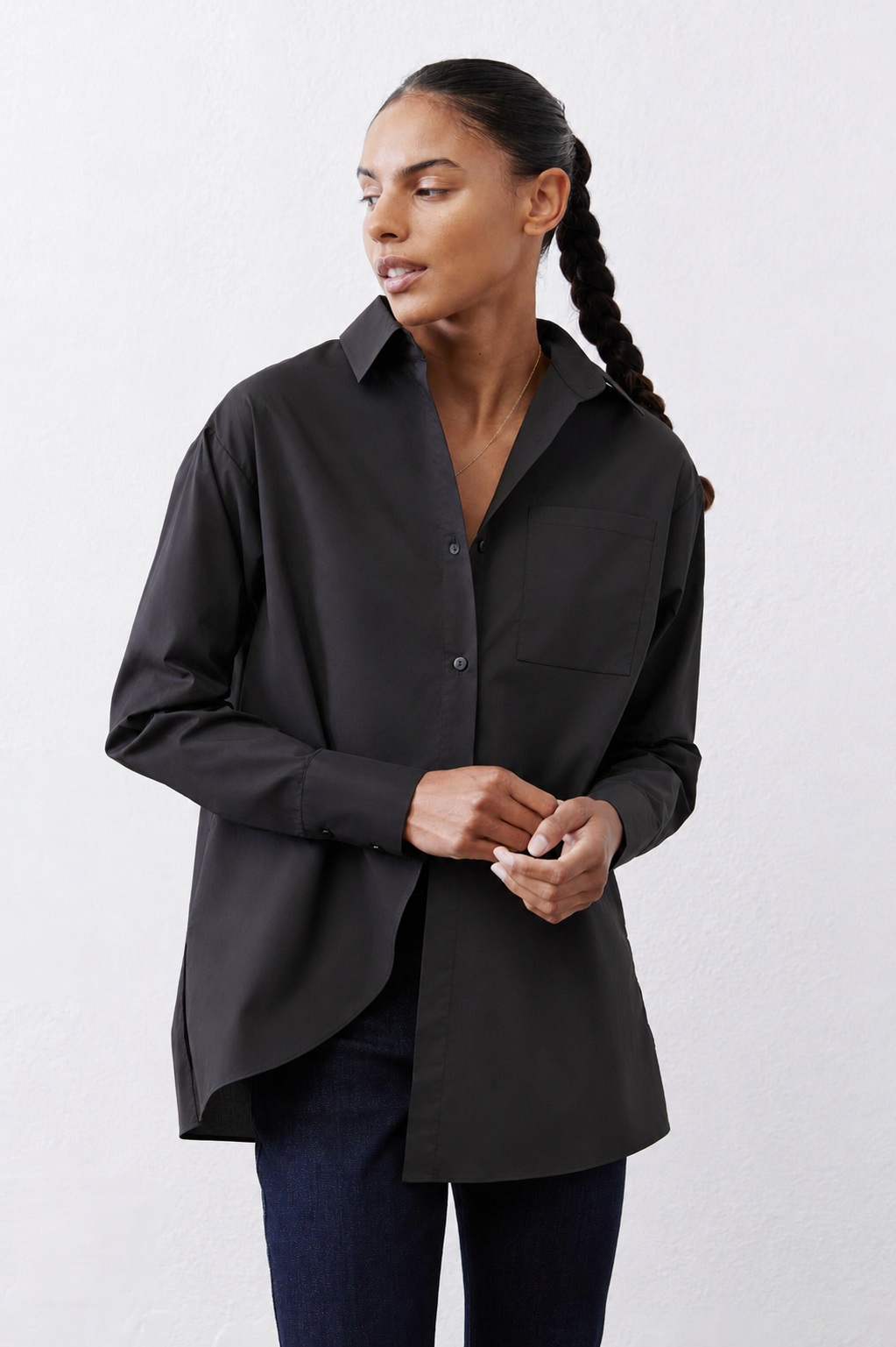 Black asymmetric button-down shirt with pointed collar and button front, long sleeves.