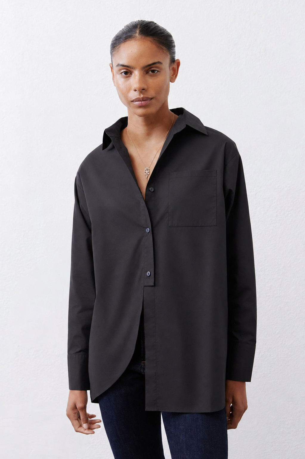 Black asymmetric button-down shirt with chest pocket, pointed collar, hip-length hem.
