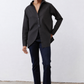 Black asymmetric button-down shirt with button front, long sleeves, side drape hem.