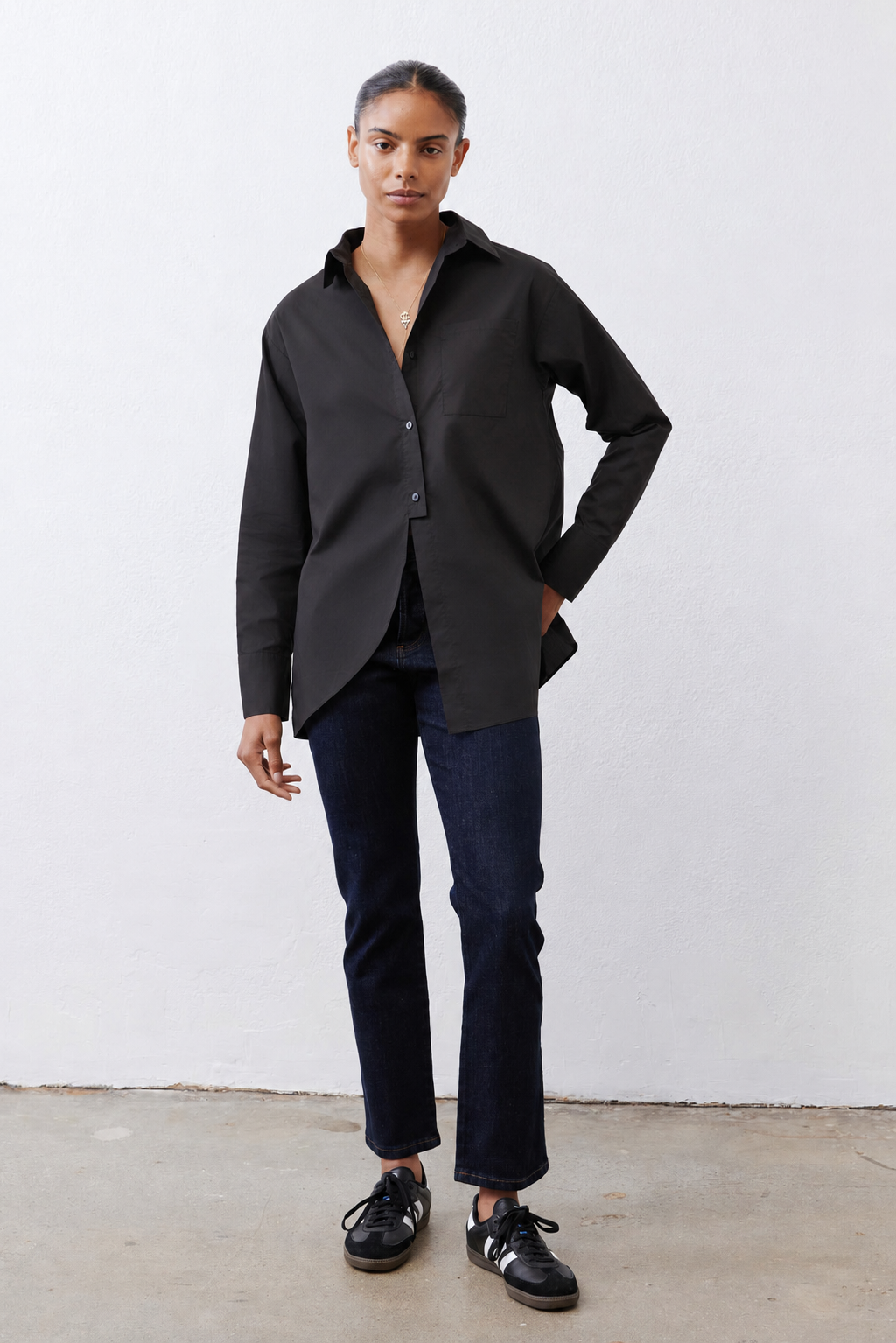 Black asymmetric button-down shirt with button front, long sleeves, side drape hem.