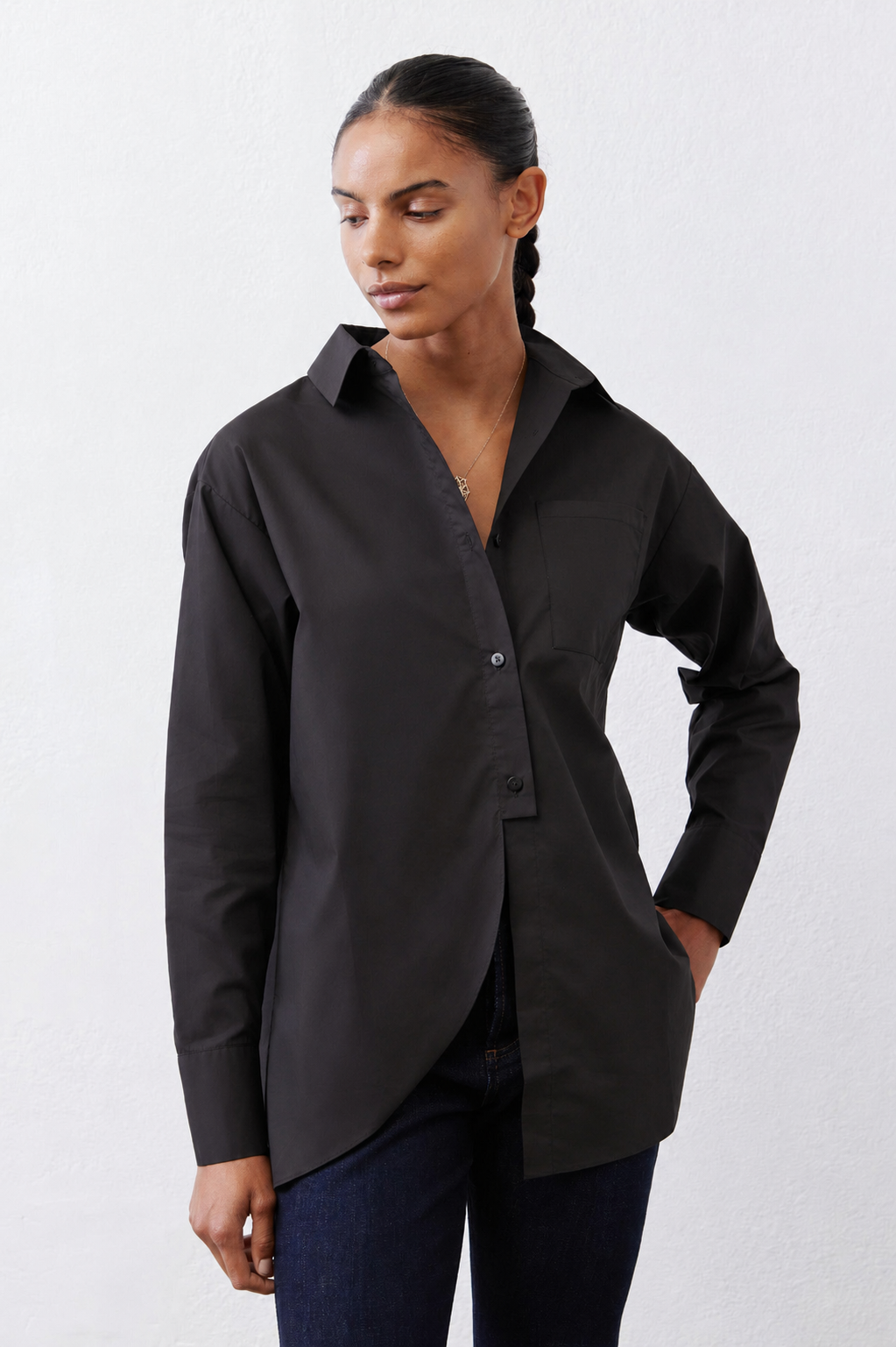 Black asymmetric button-down shirt with pointed collar and button placket, long sleeves.