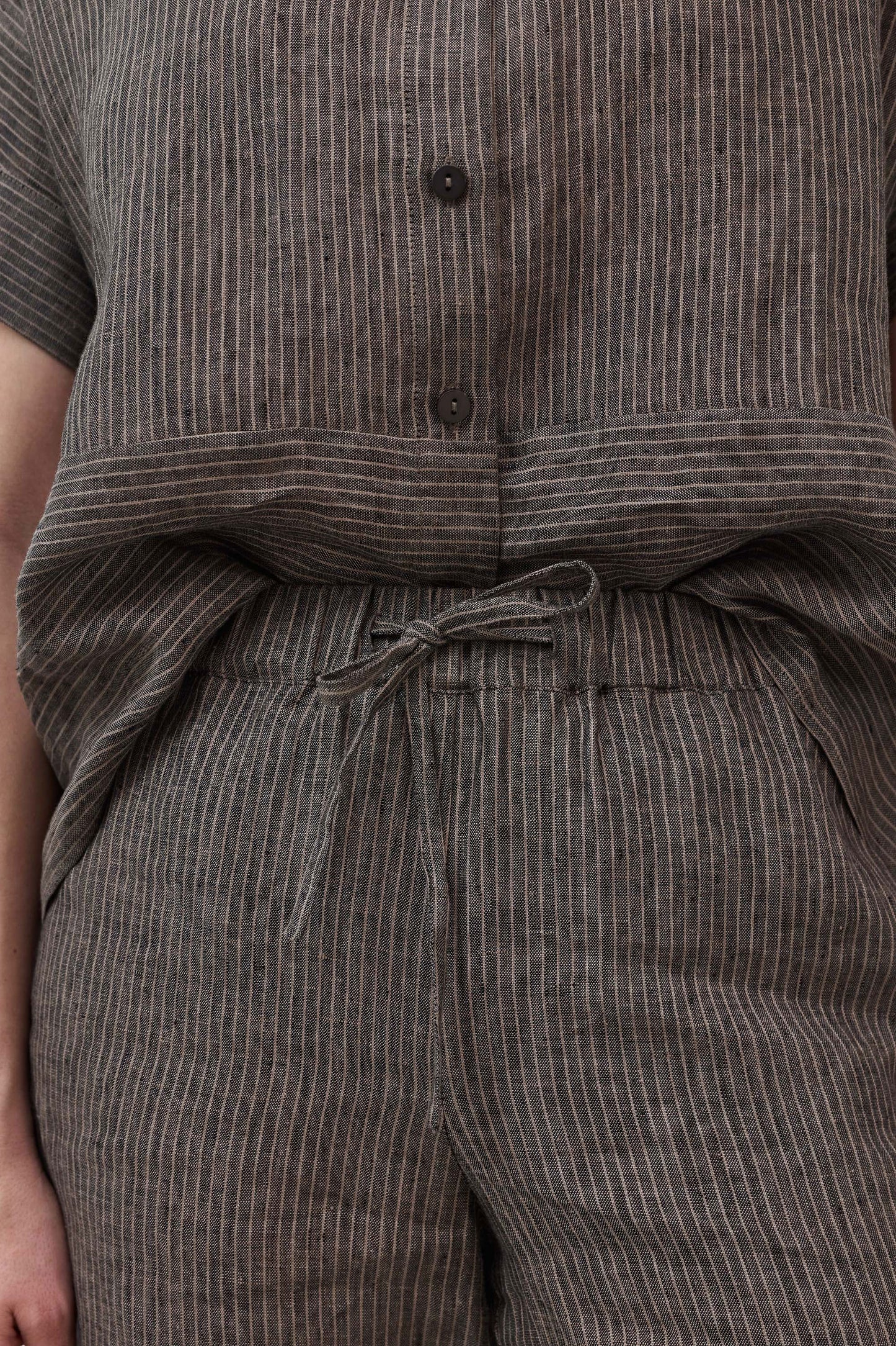 Charcoal pinstripe linen pants with tied drawstring at elastic waistband