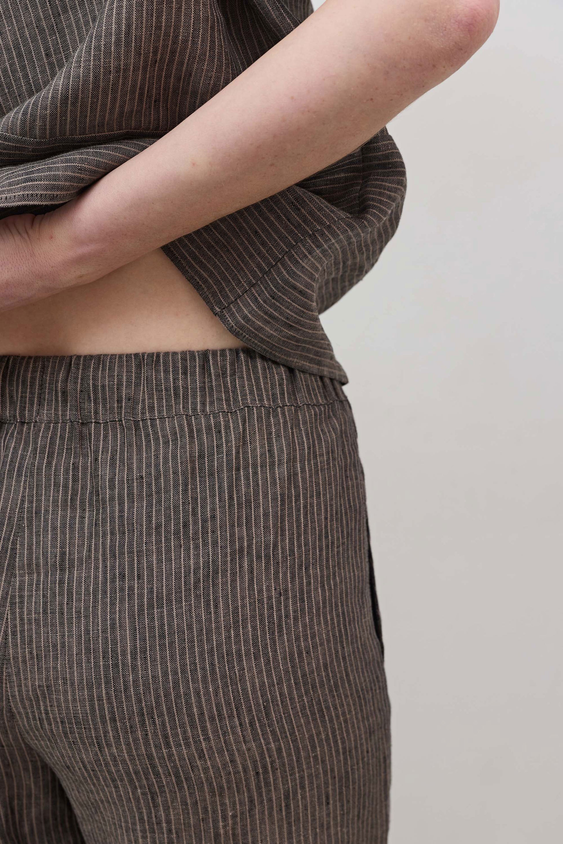 Charcoal pinstripe linen pants fabric with front seam and drawstring waist