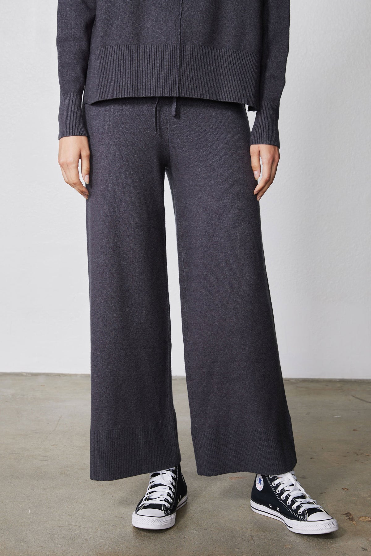 Charcoal wide-leg lounge pants with drawstring, paired with cowl hoodie sleeves