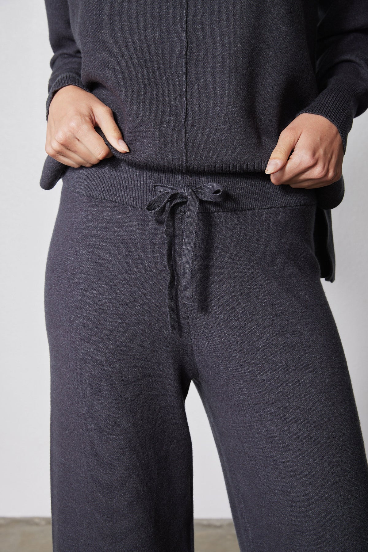 Charcoal lounge pants with tied drawstring at waist, paired with cowl hoodie