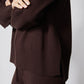 Chocolate plum wide-leg pants with ribbed hem and sweater hem overlap, close-up